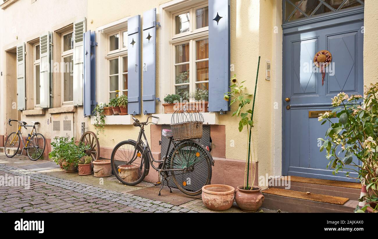 Strada acciottolata con case medievali con biciclette e vasi di fiori rende per foto perfetta scena idilliaca nel villaggio murato di Rothenburg, Germania Foto Stock