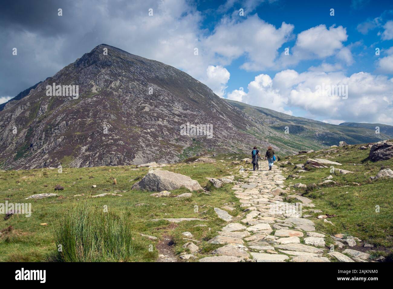 Escursionisti nella valle di Ogwen, Snowdonia National Park, Galles del Nord, con Pen YR Ole Wen in lontananza Foto Stock