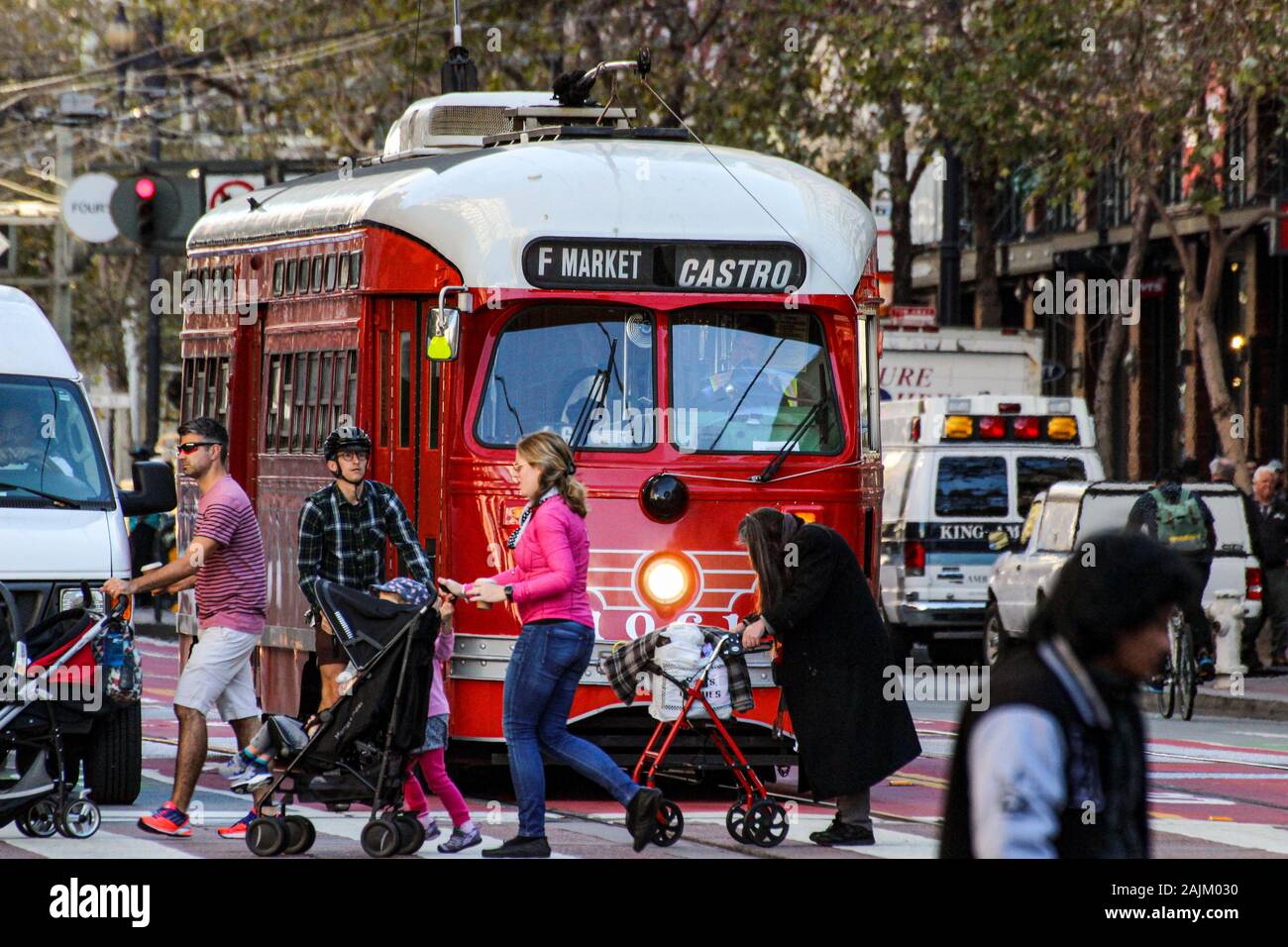 Le persone che attraversano le Market Street di fronte red vintage tram sulla linea F a San Francisco, Stati Uniti d'America Foto Stock