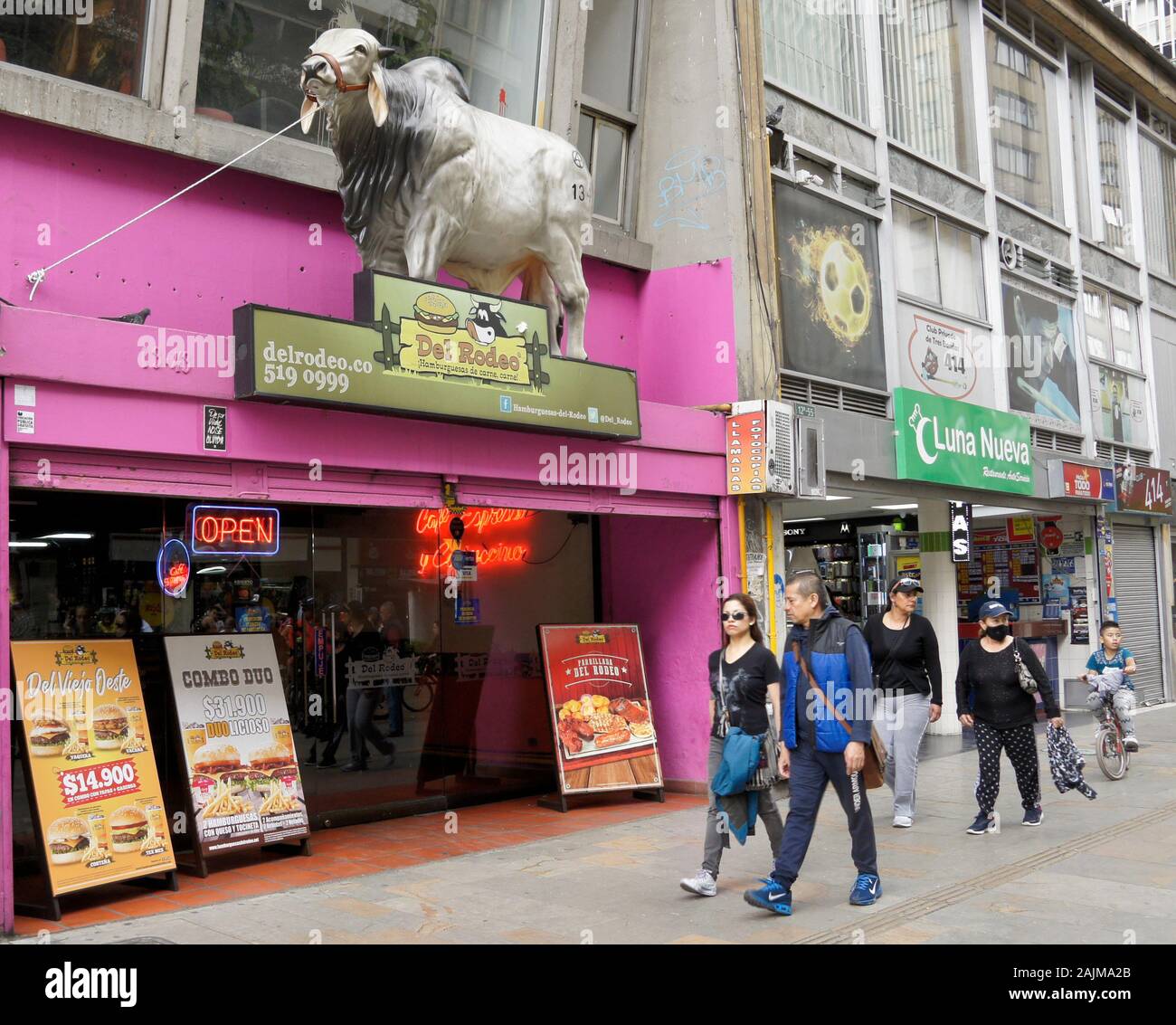 La gente camminare passato del rodeo ristorante e negozi lungo la Carrera 7 in Candelaria distretto di Bogotà, Colombia Foto Stock