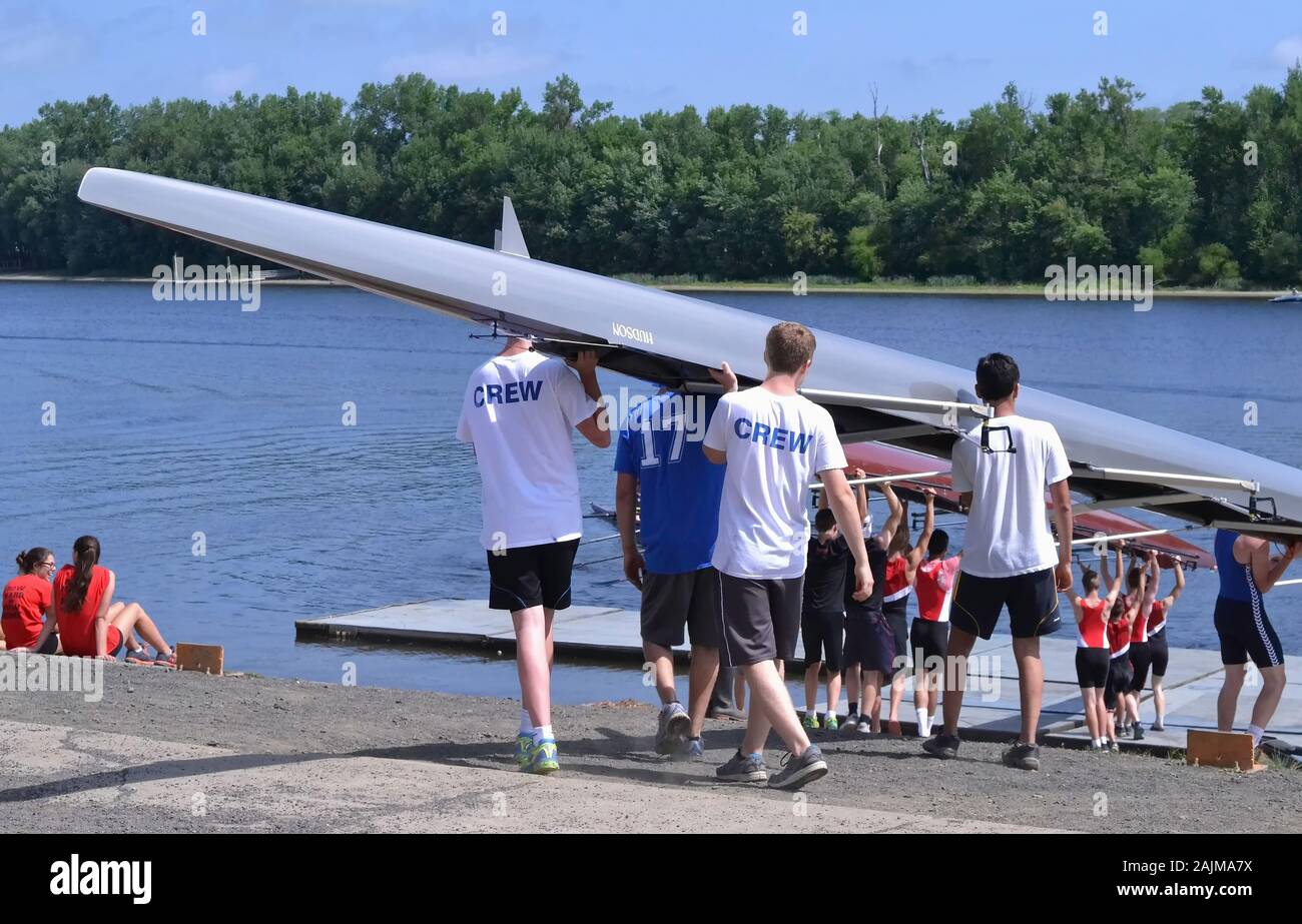 Middletown, CT / STATI UNITI D'America - 29 Maggio 2015: Middletown High School ragazzi della squadra cammina giù per il dock che trasportano la loro barca sulle loro spalle durante il Foto Stock