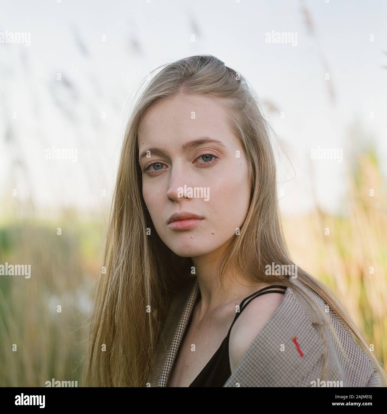 Una bella donna si erge tra le canne Foto Stock