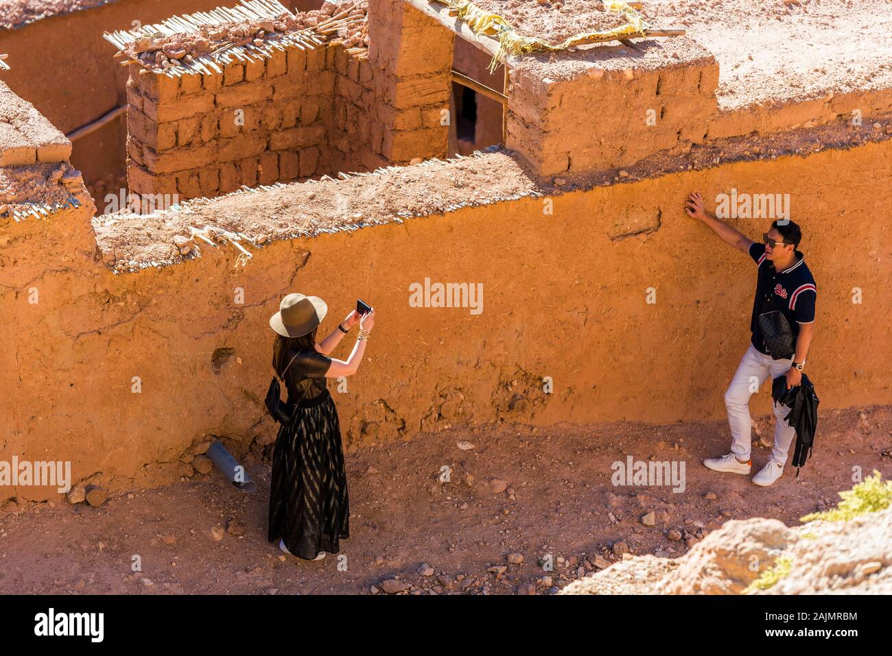 AIT-ben-Haddou, Marocco - 12 novembre 2019: un paio di turisti scattare foto vicino alla parete. Vista superiore Foto Stock