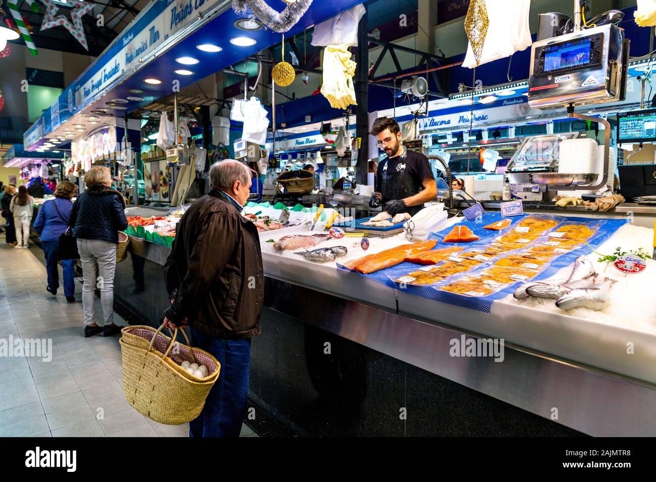 Uomo anziano tenendo un cestello, shopping presso un pesce in stallo Mercat de l'Olivar, Palma di Mallorca, Spagna Foto Stock