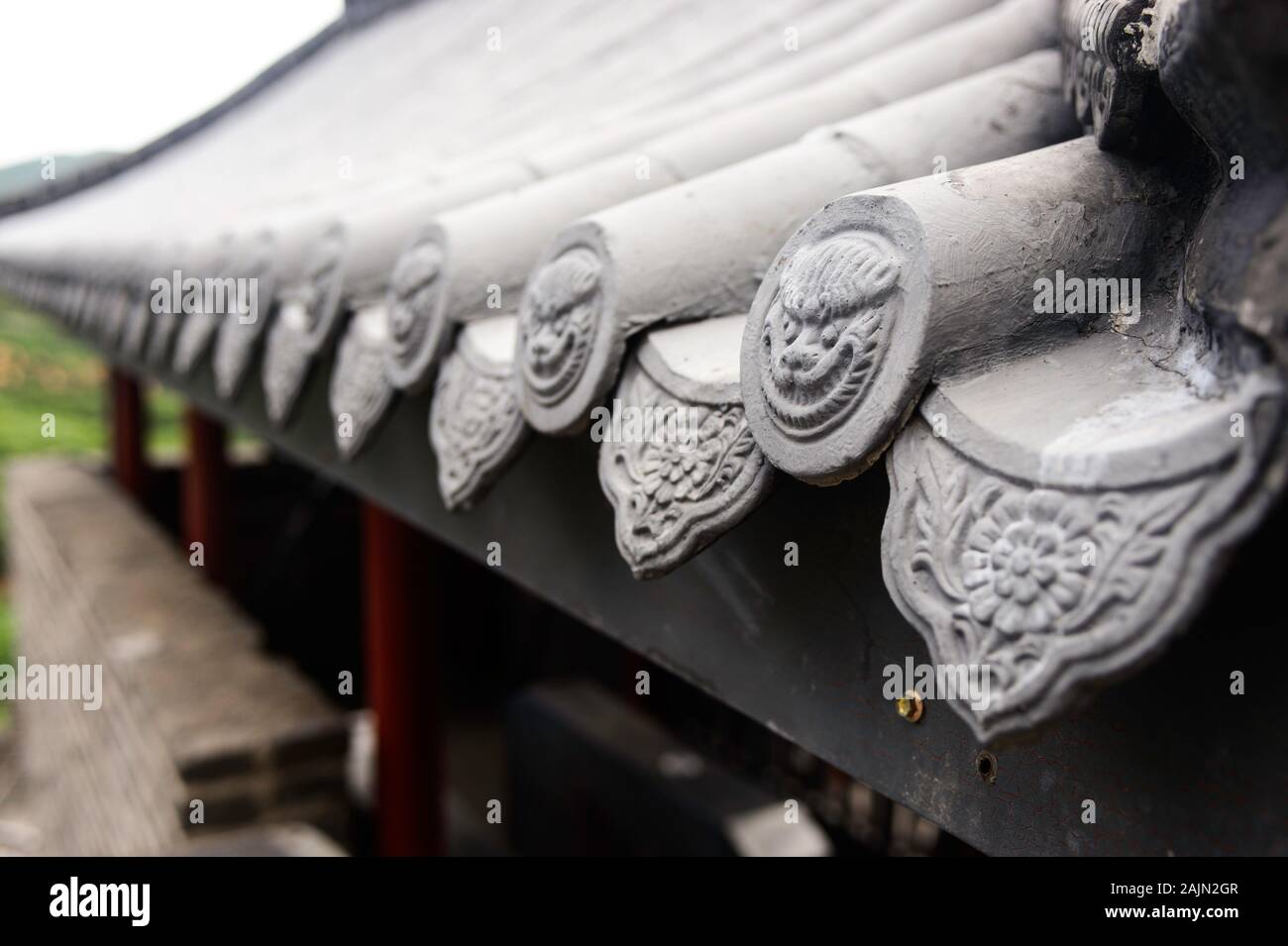 Piastrella cinese bordo tetto caps adornano il tetto di tegole presso il sito di Badaling della Grande Muraglia Cinese. Foto Stock