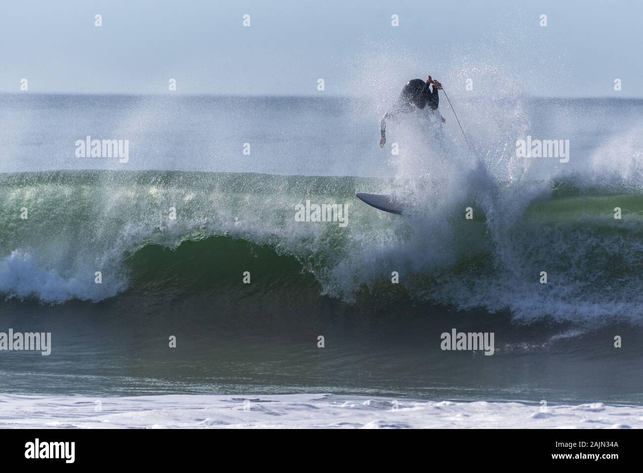 Surfer è capovolto e cade dopo la pulizia sulla grande onda ride in California. Foto Stock