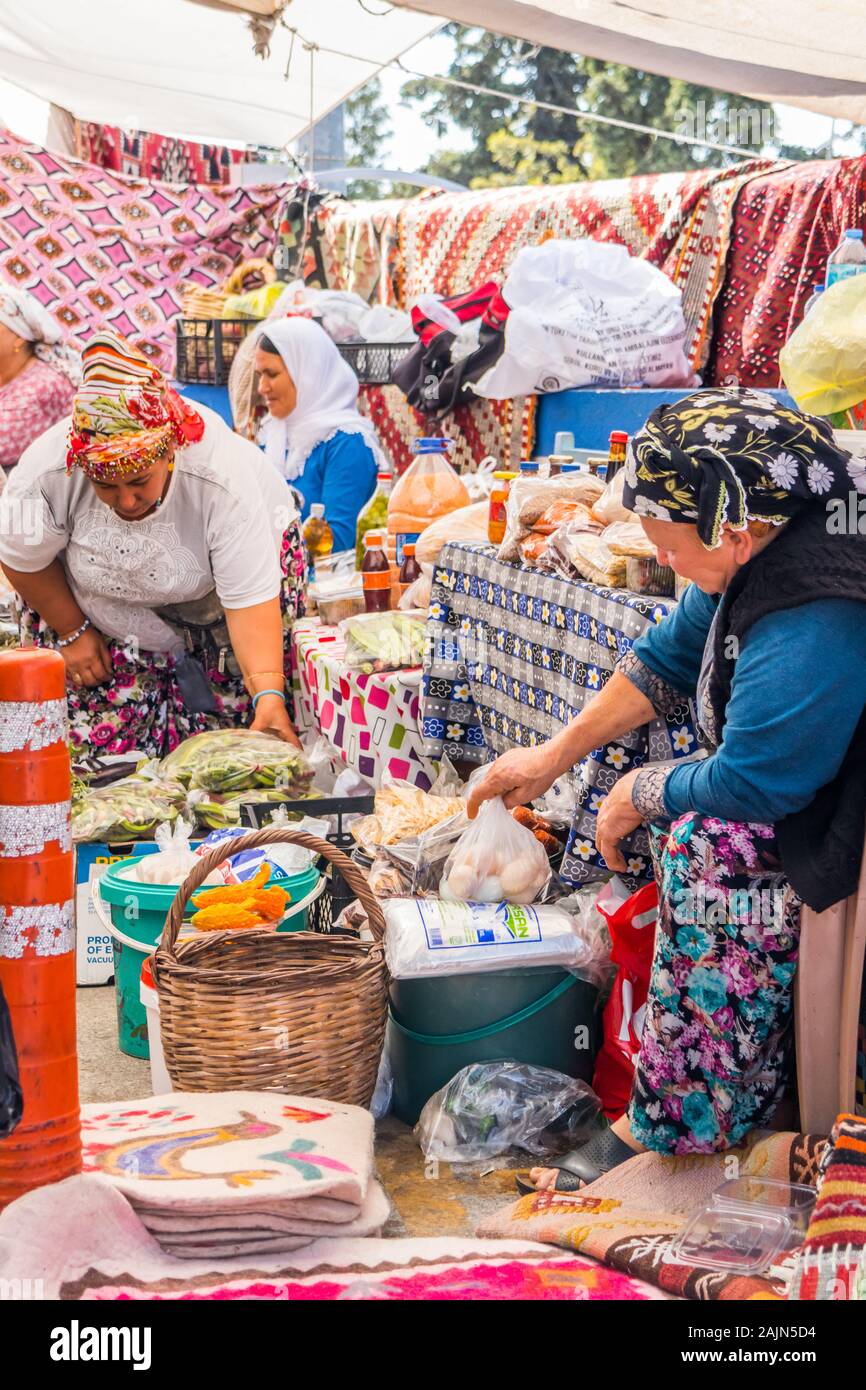 Bodrum, Turchia - 24 Settembre 2019: le donne turche la vendita di tappeti e negozio di souvenir sul mercato. Il mercato è tenuto a settimana Foto Stock