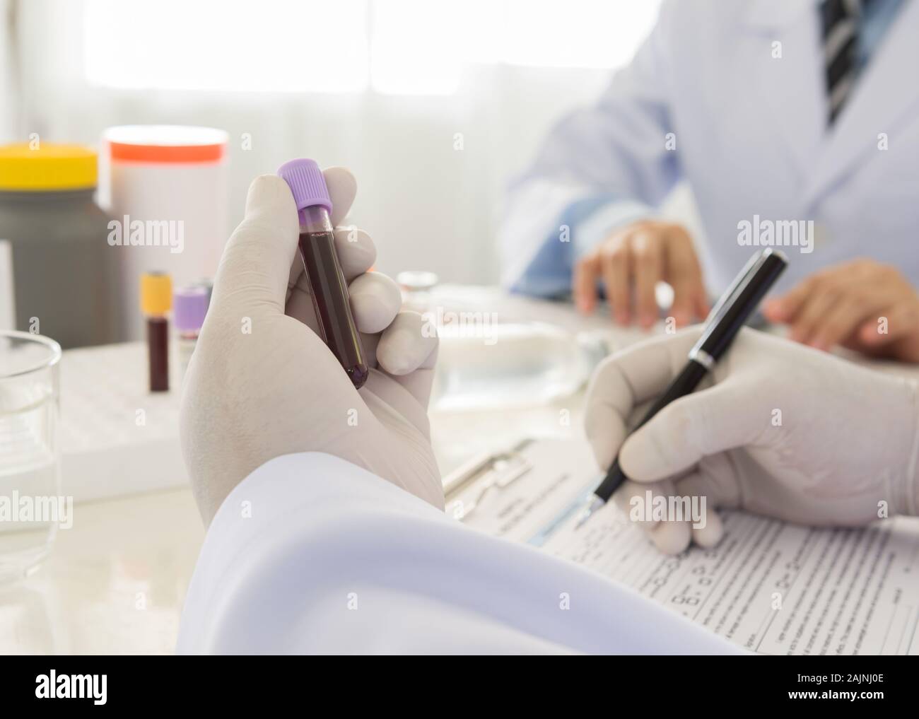 Medico tenendo una bottiglia del campione di sangue in laboratorio. scienza e concetto medico Foto Stock