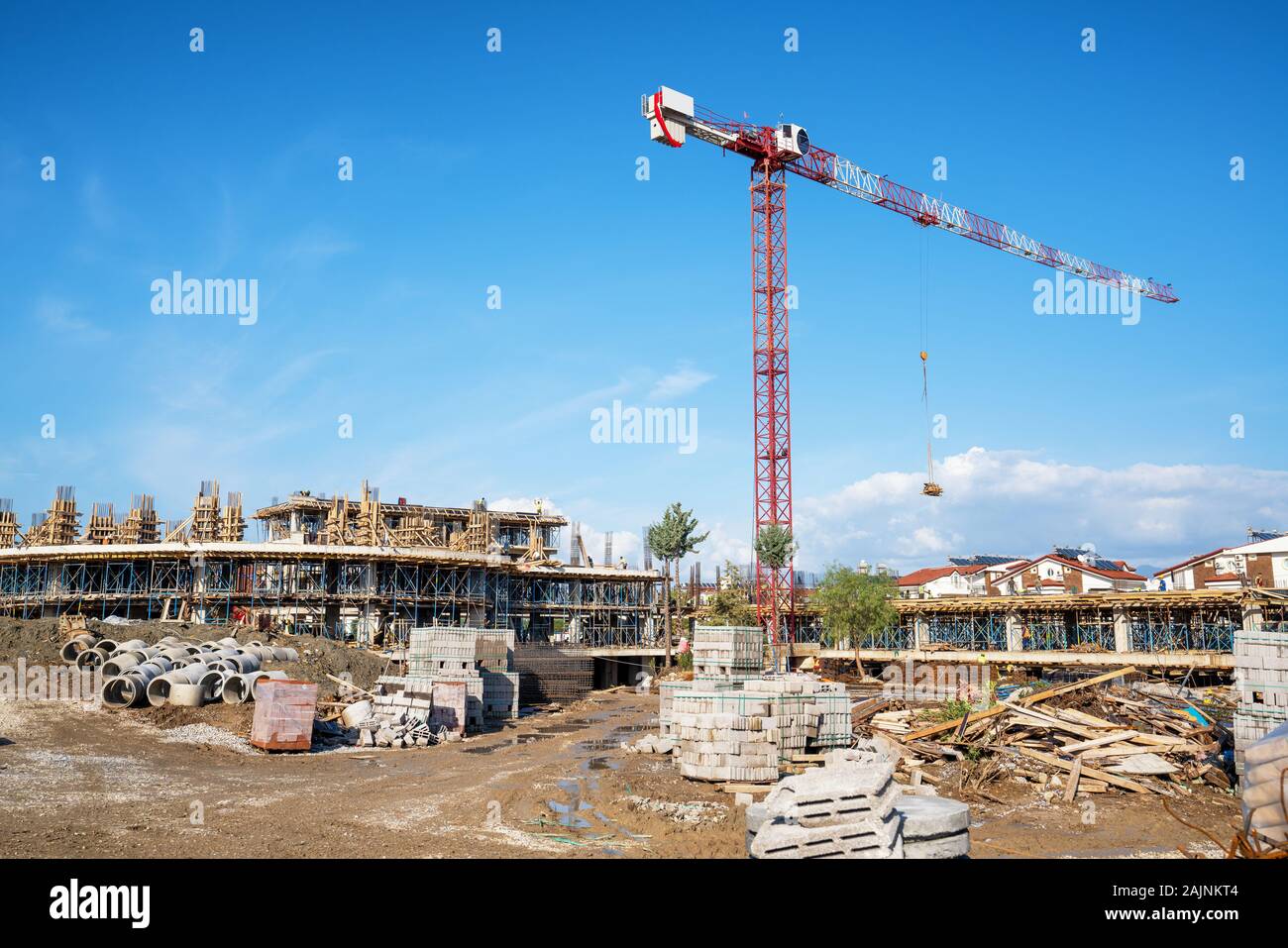 La costruzione di un edificio con una gru da cantiere contro il cielo blu. Foto Stock