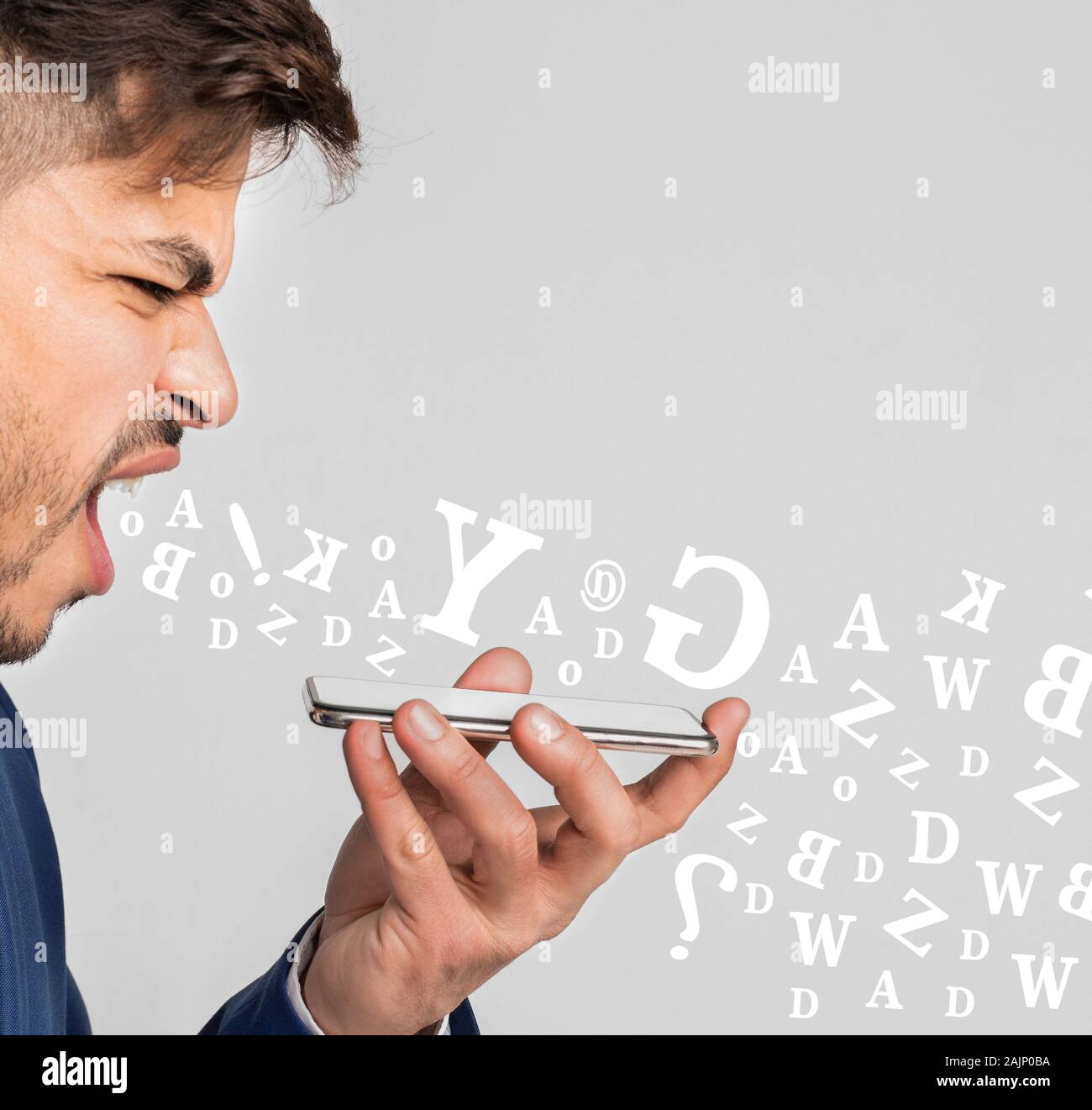 Imprenditore arrabbiato urlando a smartphone, avendo conversazioni stressanti, diverse lettere alfabeto battenti fuori della sua bocca su sfondo chiaro Foto Stock
