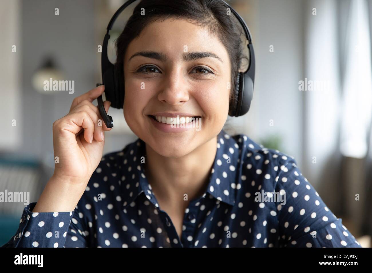Sorridente ragazza indiana professional indossare cuffie guardare webcam Foto Stock
