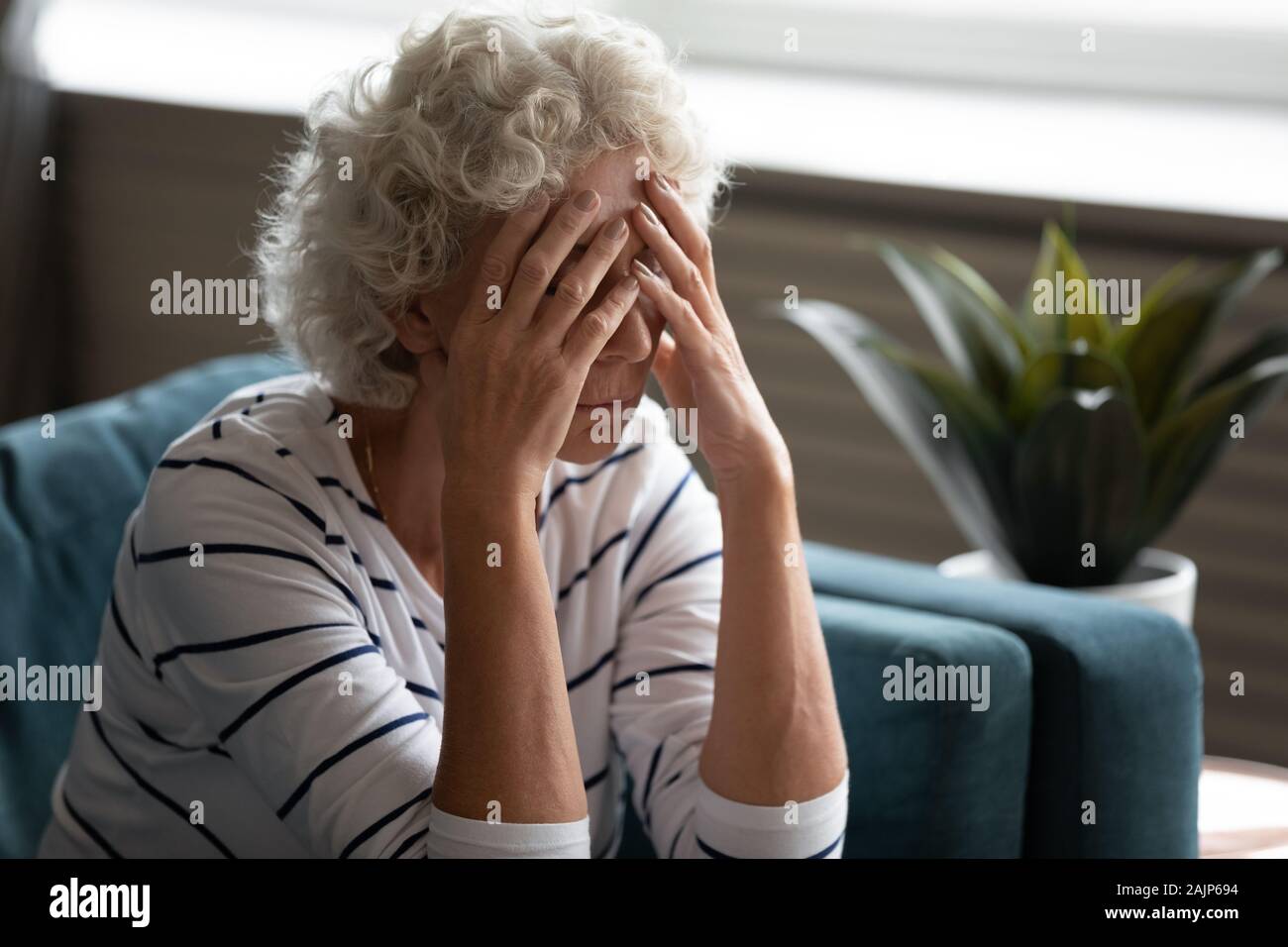 Donna anziana coperto il viso con le mani il pianto si sente disperati Foto Stock