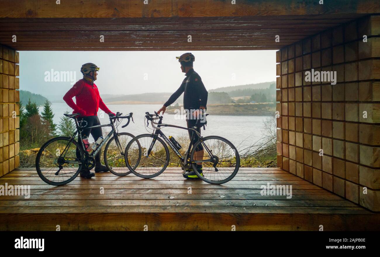 Kielder serbatoio acqua, Northumberland, Regno Unito. Dal 5 gennaio 2020. I ciclisti prendere una pausa di una giornata in bicicletta intorno a Kielder serbatoio acqua del Northumberland per guardare fuori sul Kielder acqua da una nuova scultura della quale è stato appena installato caller "time-lapse" creato dall'artista David Rickard. Credito: Phil wilkinson/Alamy Live News Foto Stock