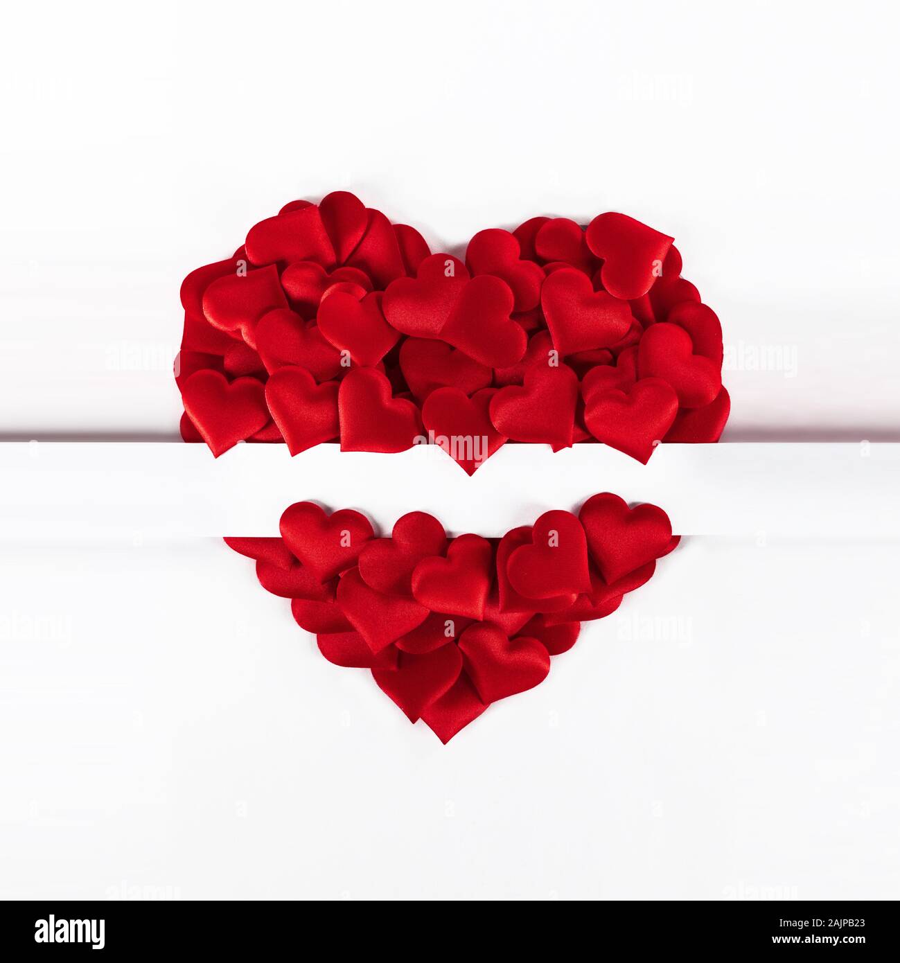 Il giorno di San Valentino molti di seta rosso cuori isolati su sfondo bianco, il concetto di amore Foto Stock