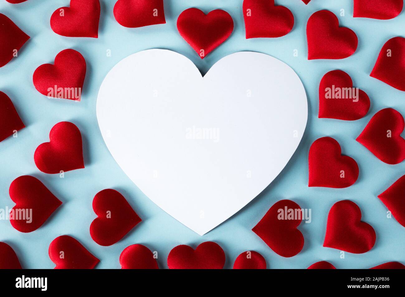 Il giorno di San Valentino Rossi molti cuori di seta e bianco a forma di cuore sulla scheda sfondo blu, il concetto di amore Foto Stock