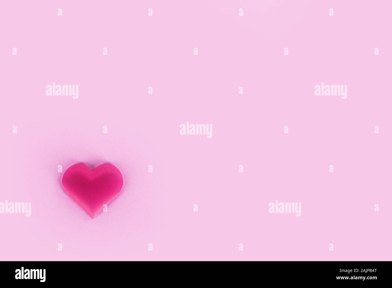 Il giorno di San Valentino cuore di seta su carta rosa, sfondo il concetto di amore Foto Stock