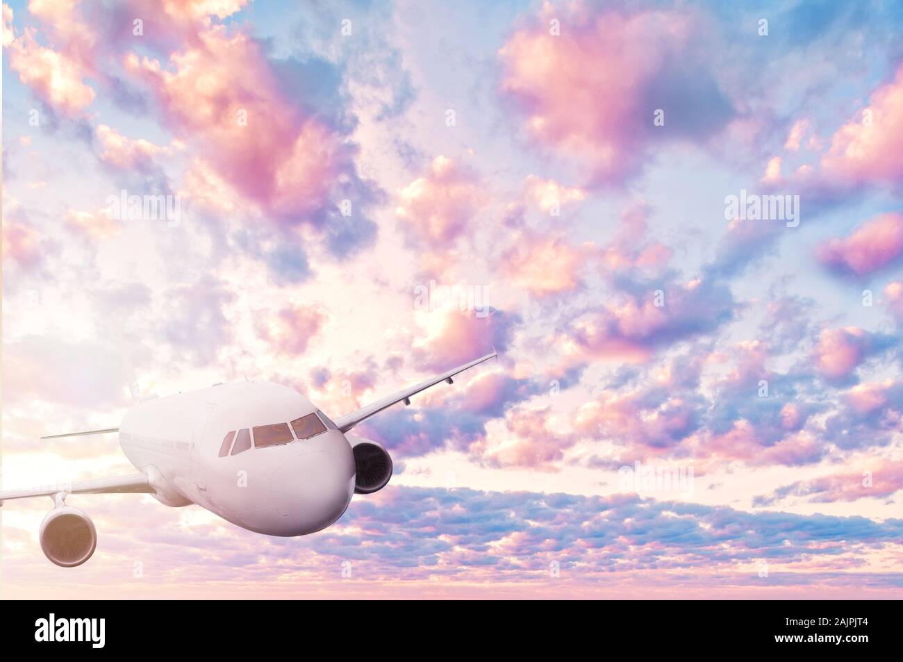 Romantico cielo rosa con le nuvole e il piano bianco. Viaggi, vacanze e sullo sfondo la luna di miele Foto Stock