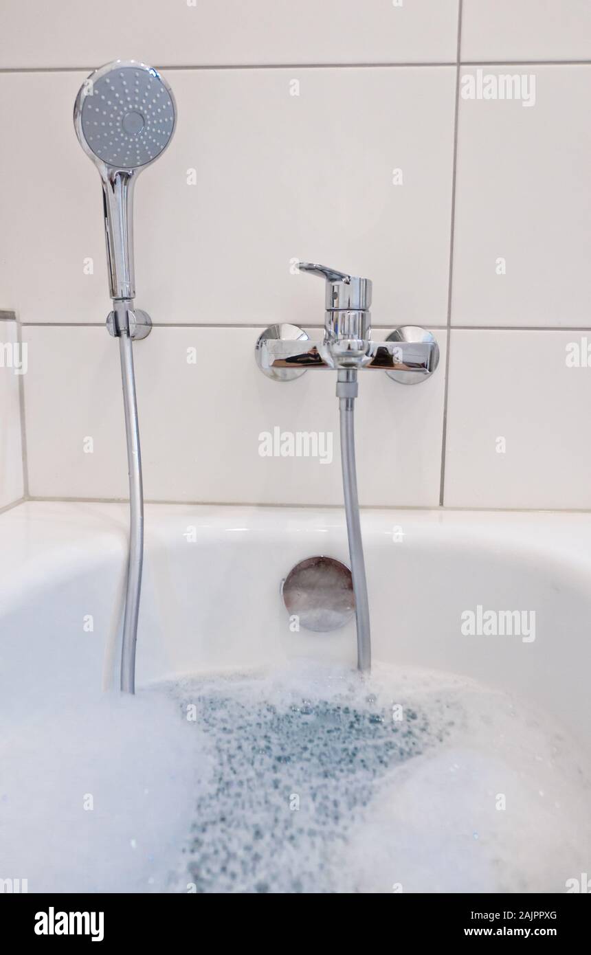 Una vasca da bagno in un bagno riempito con acqua calda e schiuma Foto  stock - Alamy