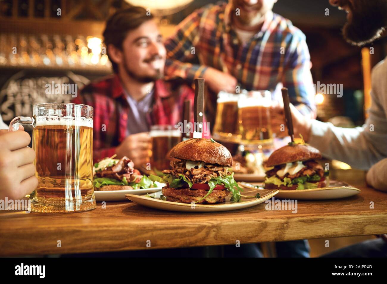 Burger con la birra sul tavolo in un bar pub. Foto Stock