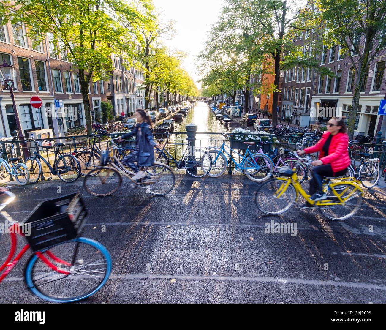 Ciclisti sono il passaggio di un ponte sul canale di Amsterdam del vecchio quartiere Jordaan (Egelantiersgracht) Foto Stock