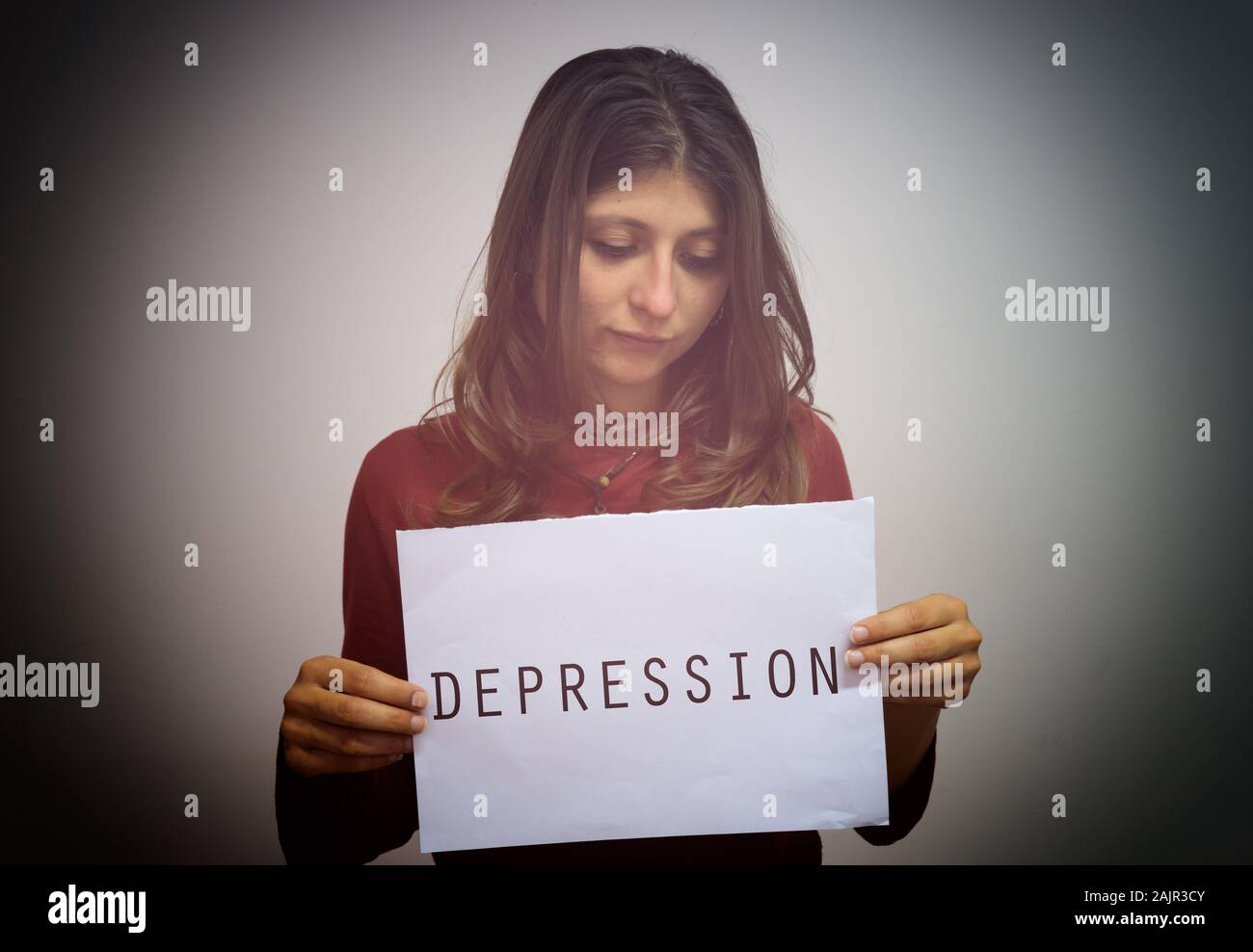 Giovani caucasici ragazza triste targhetta tenuta in mano con la parola depressione. Concetto di depressione. Foto Stock