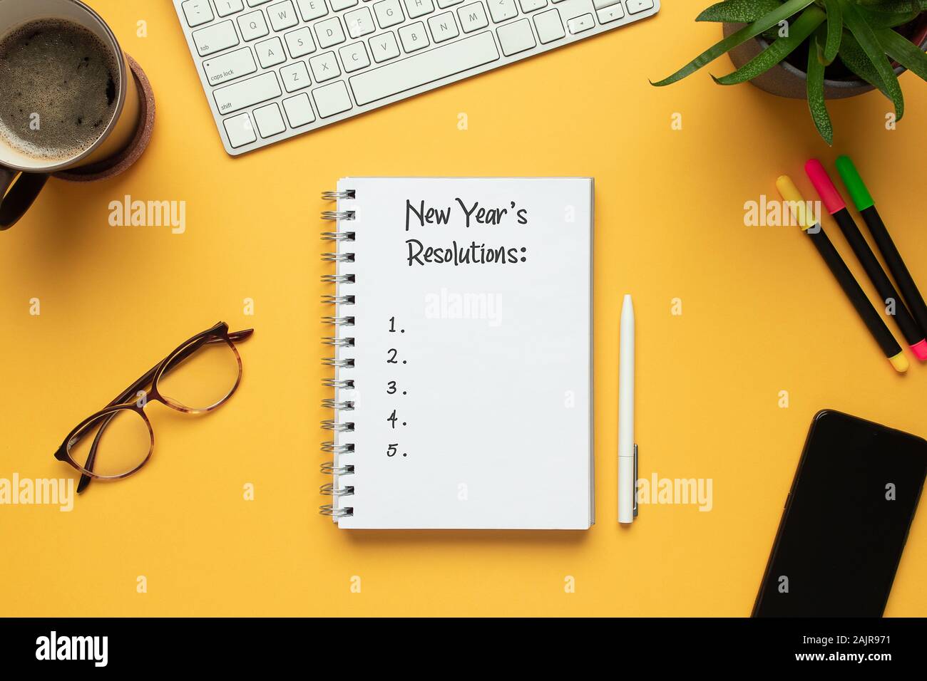 Foto di stock di 2020 anno nuovo notebook con elenco di risoluzioni e oggetti su sfondo giallo Foto Stock