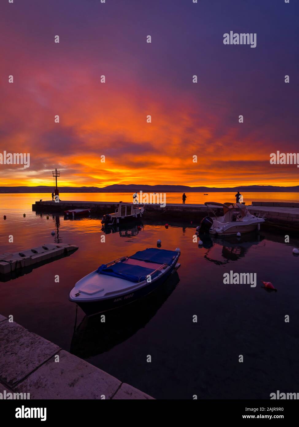 I pescatori prima del tramonto paesaggio nel piccolo porto di Malinska Croazia cielo gloriosa pacifica seawall atmosferica Ribarsko selo Haludovo Quarnaro Foto Stock