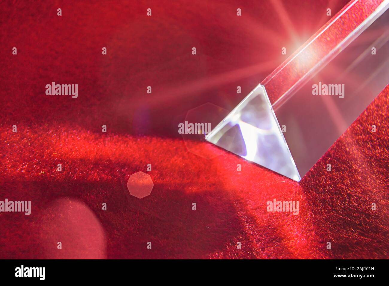 Glas prisma sul fuoco sfondo rosso con razzi lente Foto Stock