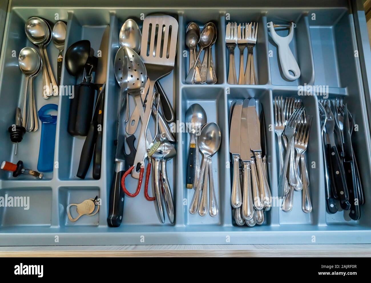 Una grande casa interno cucina cassetto riempita con una collezione di utensili da cucina e posate Foto Stock