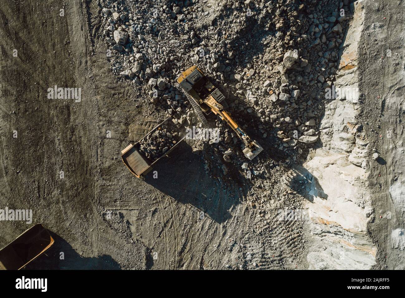 Macchinari per l'estrazione mineraria che lavorano su rocce da una vista aerea Foto Stock