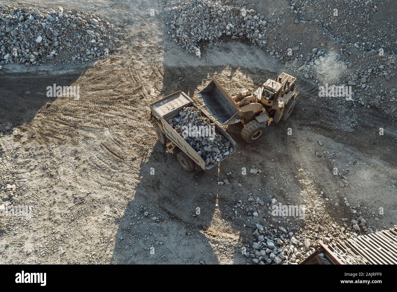 Macchinari per l'estrazione mineraria che lavorano su rocce da una vista aerea Foto Stock