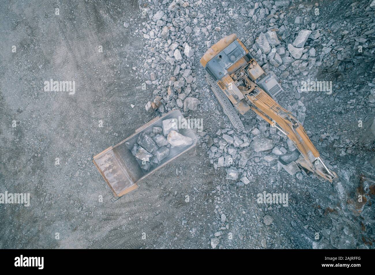 Macchinari per l'estrazione mineraria che lavorano su rocce da una vista aerea Foto Stock