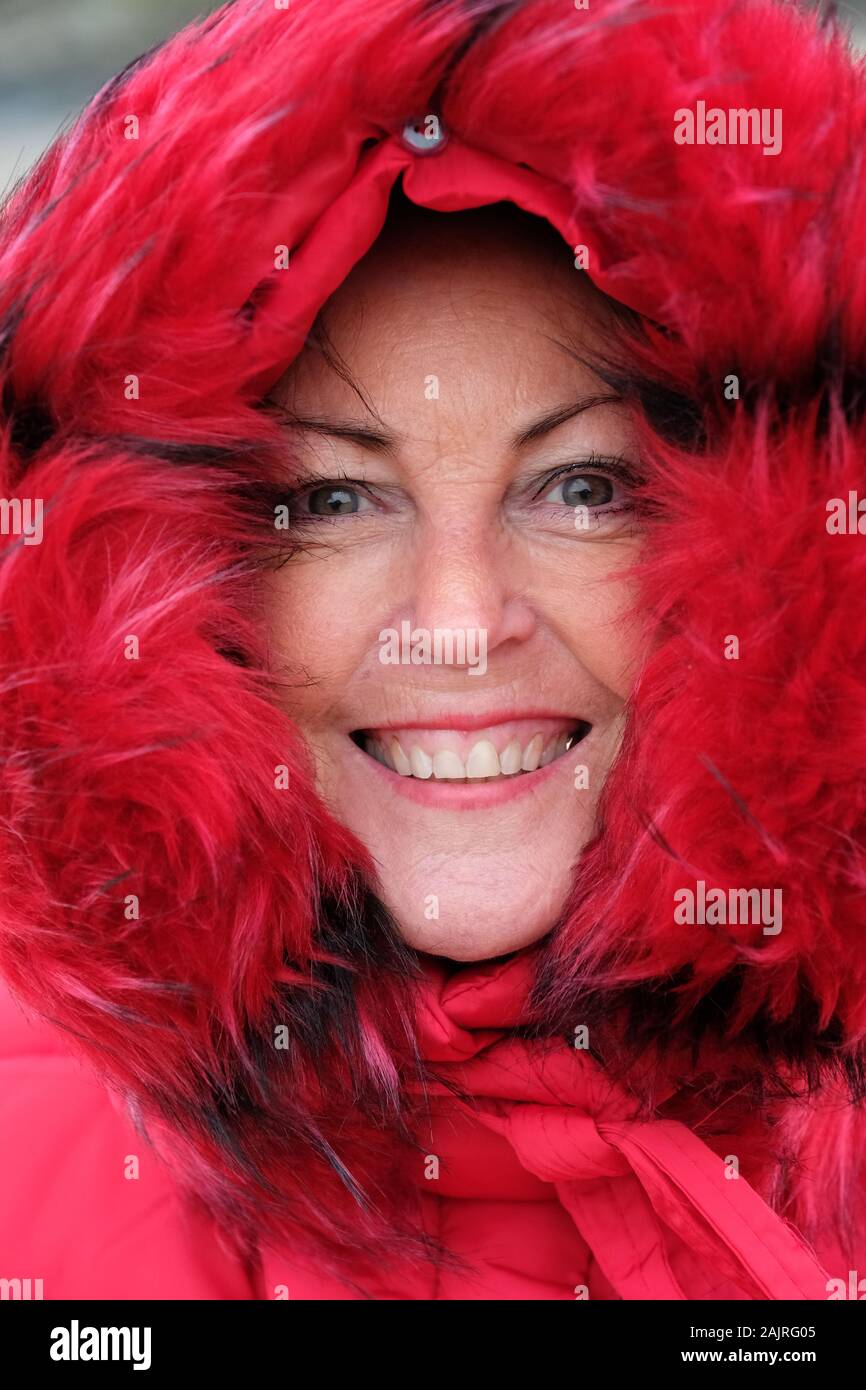Close-up di un maturo, bella donna in un rosso, foderata in pelliccia parka - Giovanni Gollop Foto Stock