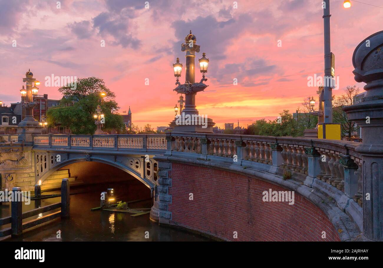 Blu Blauwbrug ponte sul fiume Amstel di Amsterdam al tramonto sera primaverile, Olanda. Foto Stock