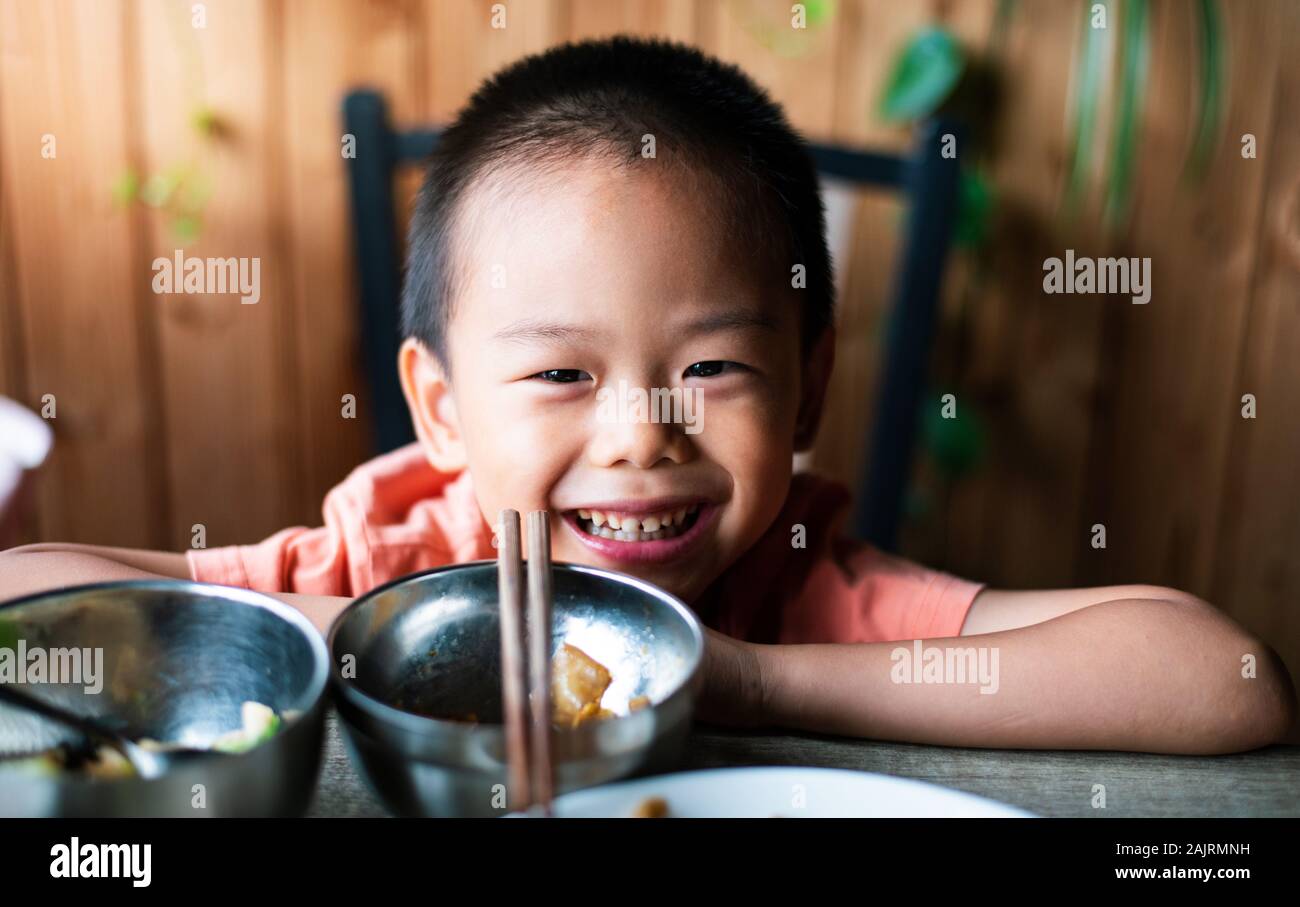 Carino ragazzo asiatico con pranzo presso il ristorante Foto Stock
