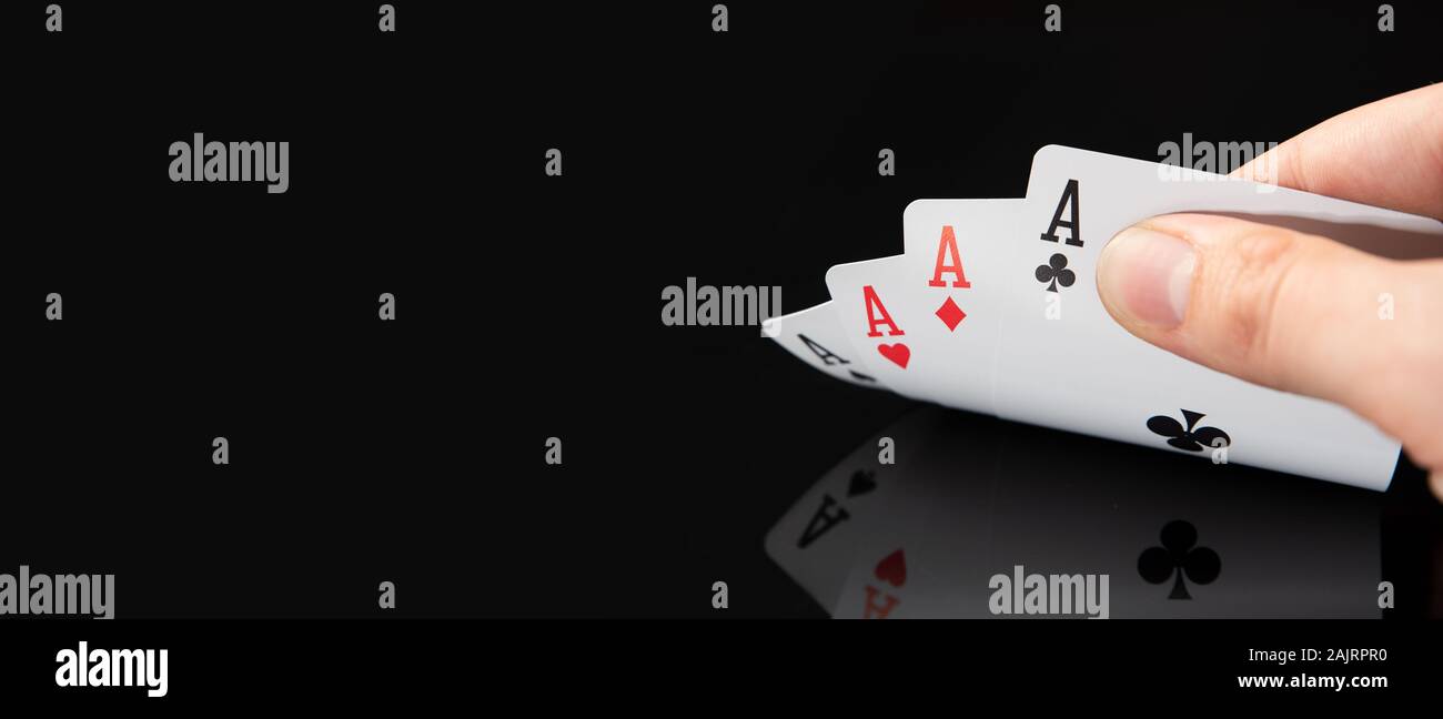 Uomo con carte in tavola nera con la riflessione. Il gioco del poker, gioco d'azzardo nel concetto di casinò. Foto Stock