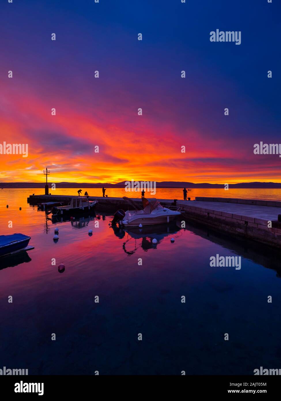 I pescatori prima del tramonto paesaggio nel piccolo porto tranquillo in Malinska in Croazia Foto Stock