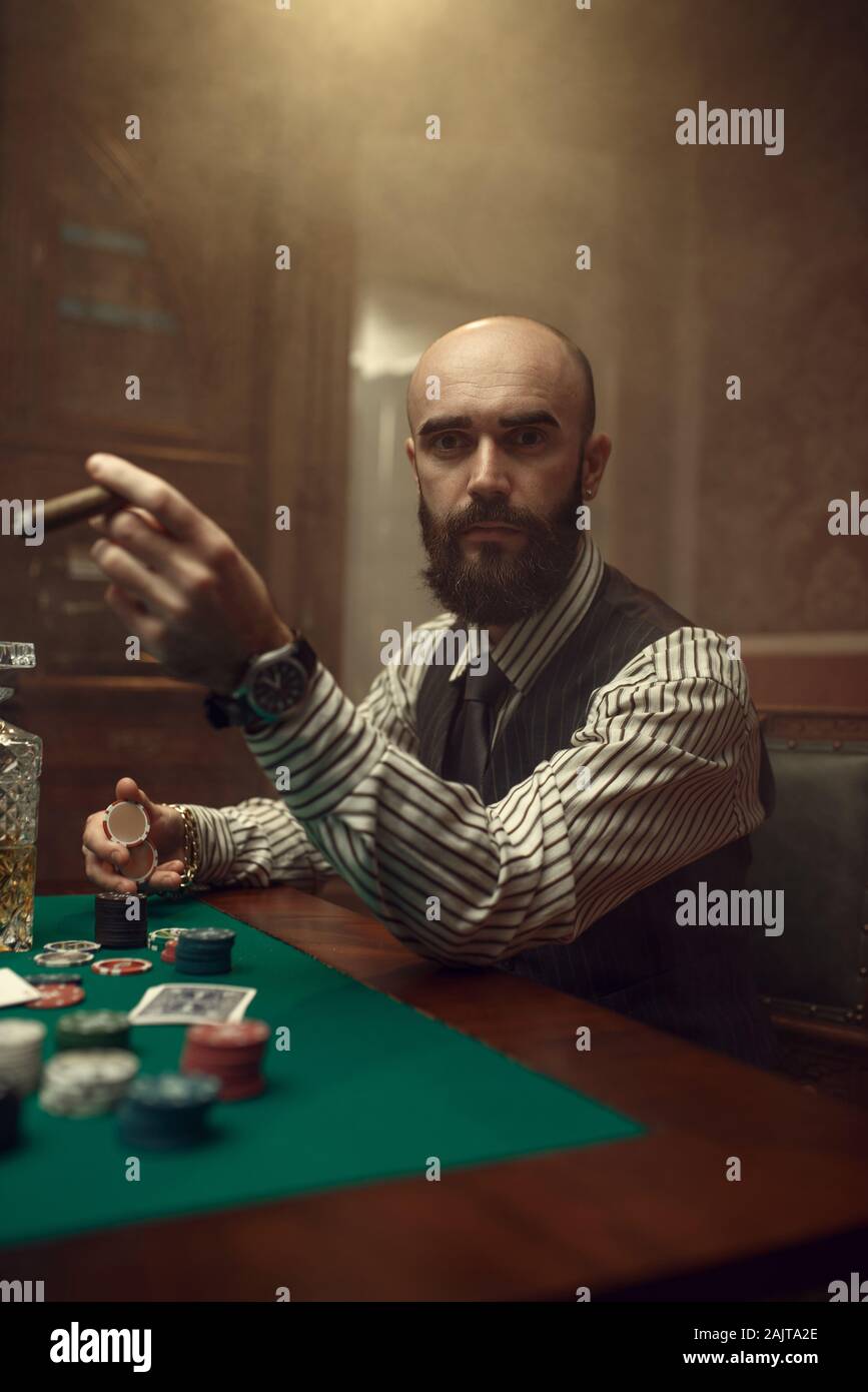 Barbuto giocatore di poker con sigaro giocare nel casinò Foto Stock