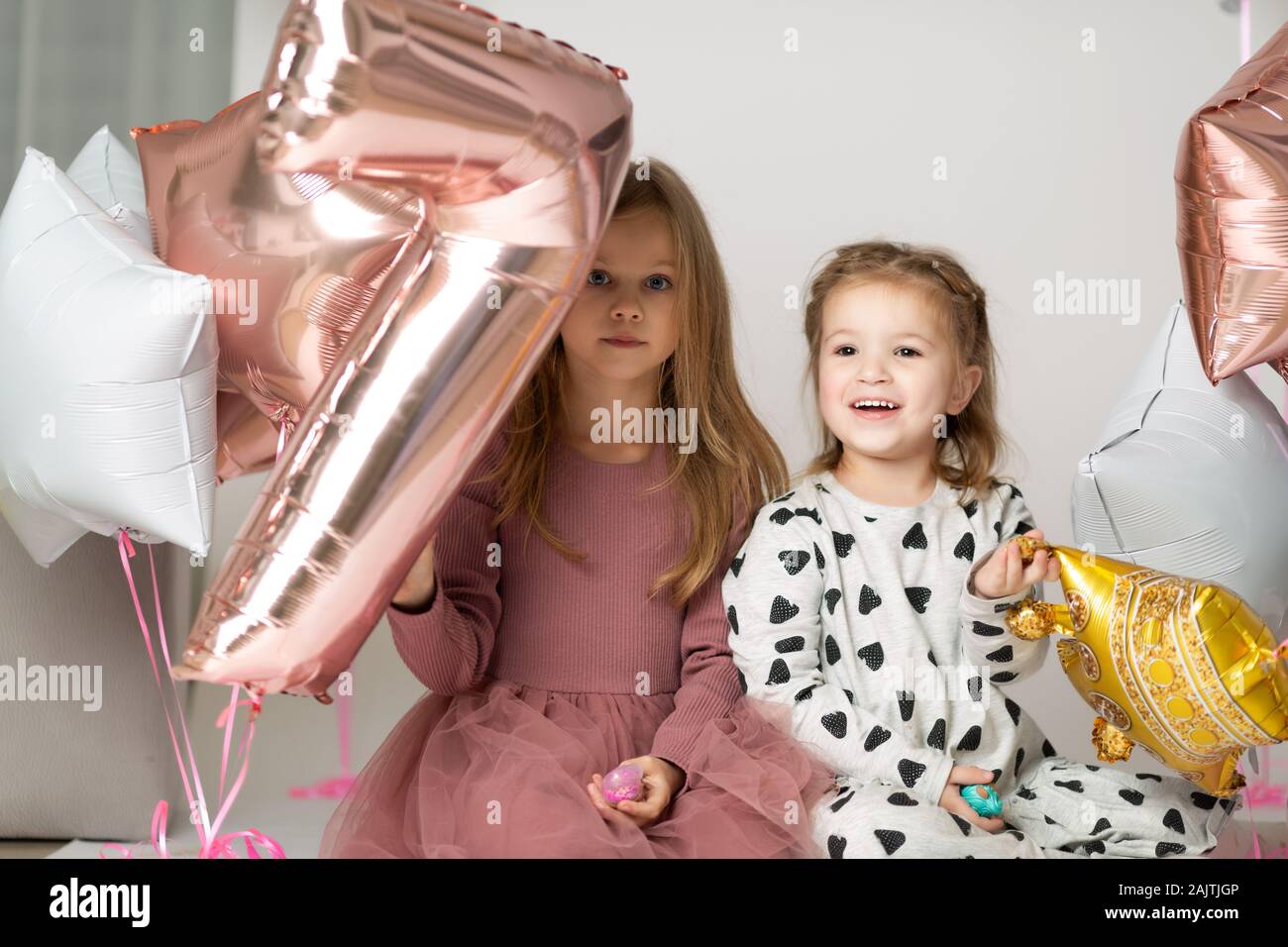 Ragazze divertente giocare con un palloncino come un numero sette Foto Stock