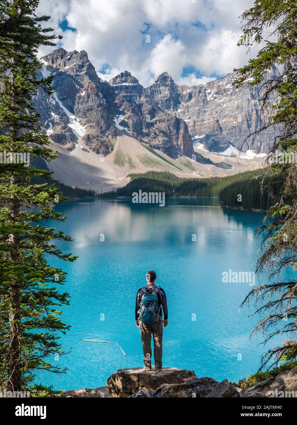 Escursionista guardando la vista al Lago Moraine durante l'estate nel Parco Nazionale di Banff, Canadian Rockies, Alberta, Canada. Foto Stock