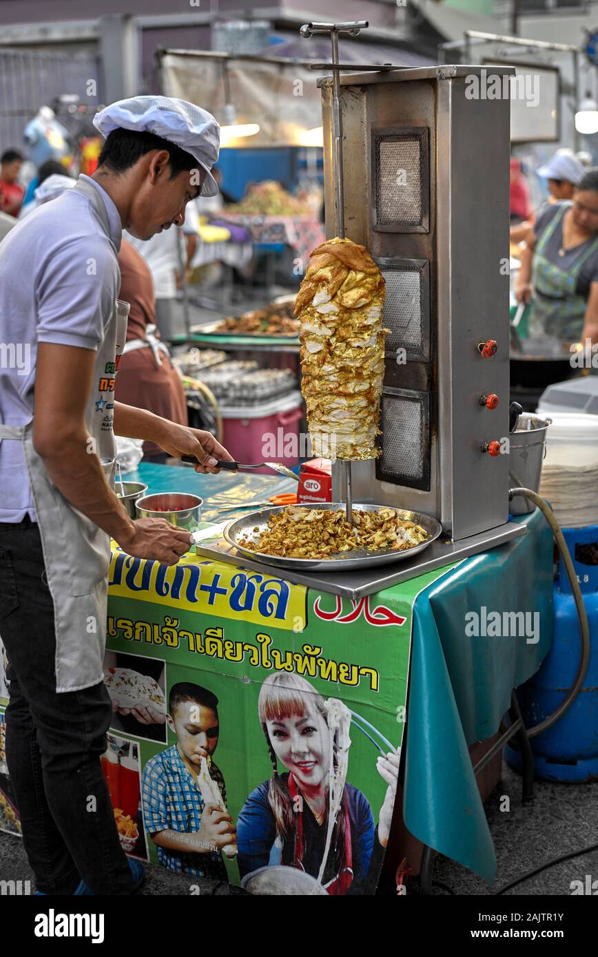 Kebab chef a un cibo di strada venue la cottura da un grill e affettare il cibo cotto per la vendita Foto Stock