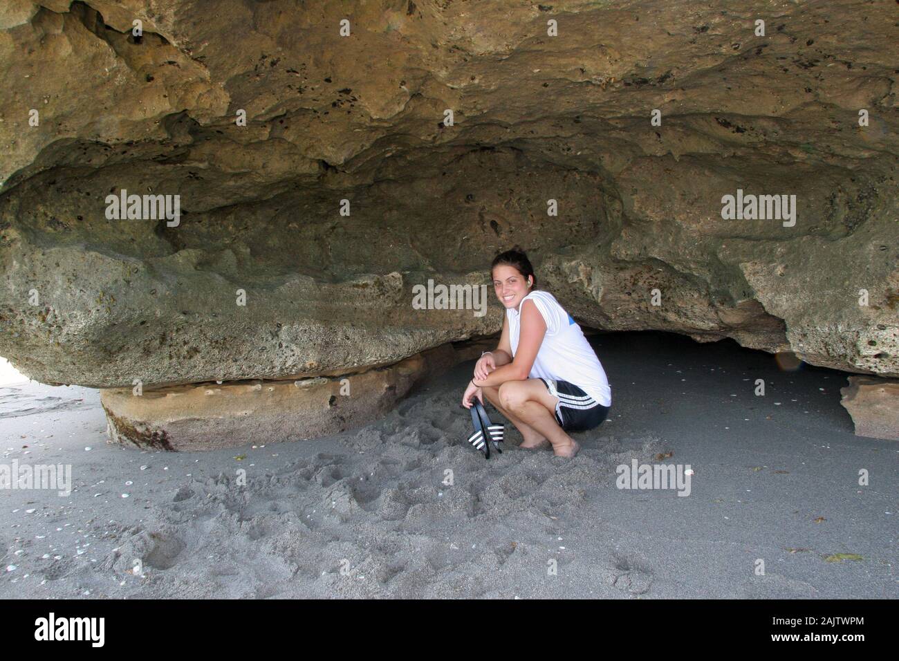 Giovane donna esplora il Anastasia affioramenti di pietra calcarea in rocce di soffiaggio preservare sull isola di Jupiter, Florida il chiaro pomeriggio senza nuvole. Foto Stock