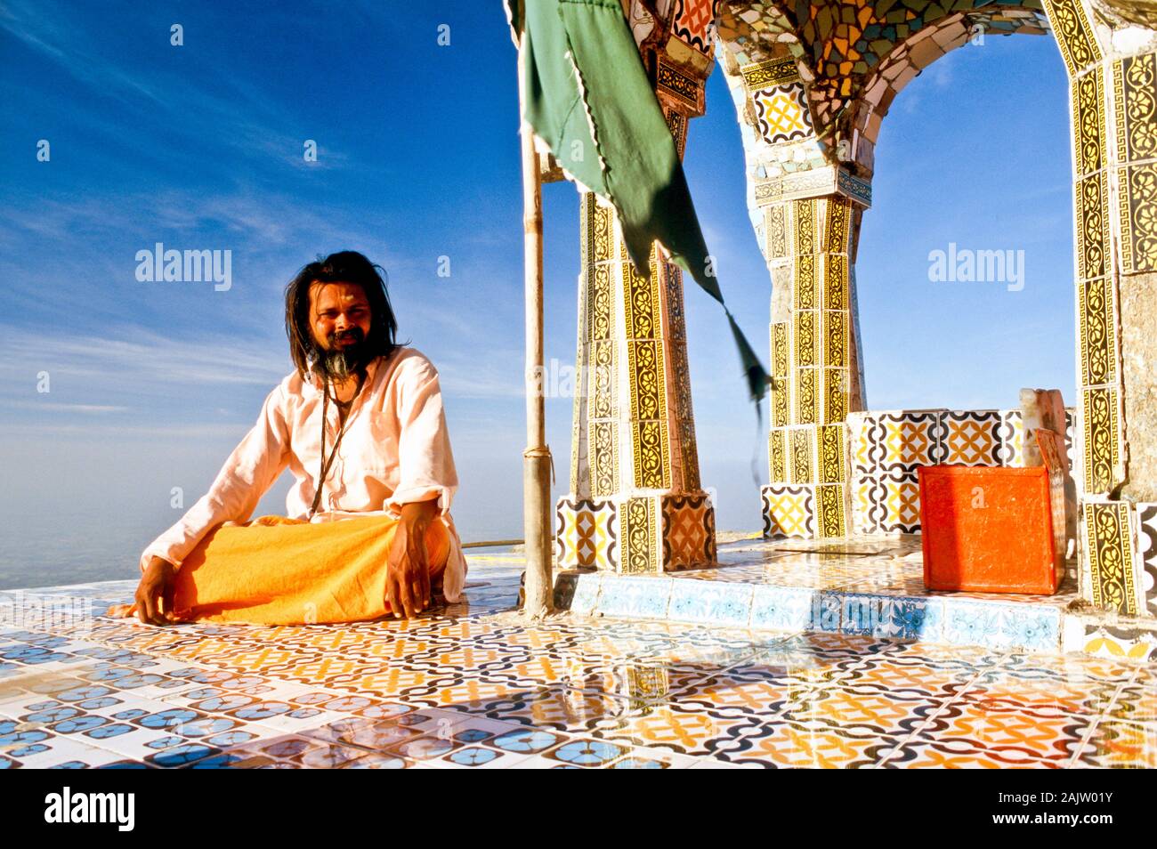 Sadhu avendo cura di un tempio sulla sommità del Girnar Hill Foto Stock