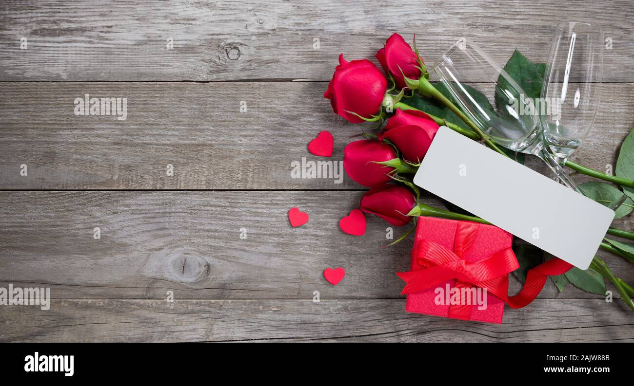 Il giorno di San Valentino card. Una confezione regalo rossa con due bottiglie di champagne di con e una nota Foto Stock