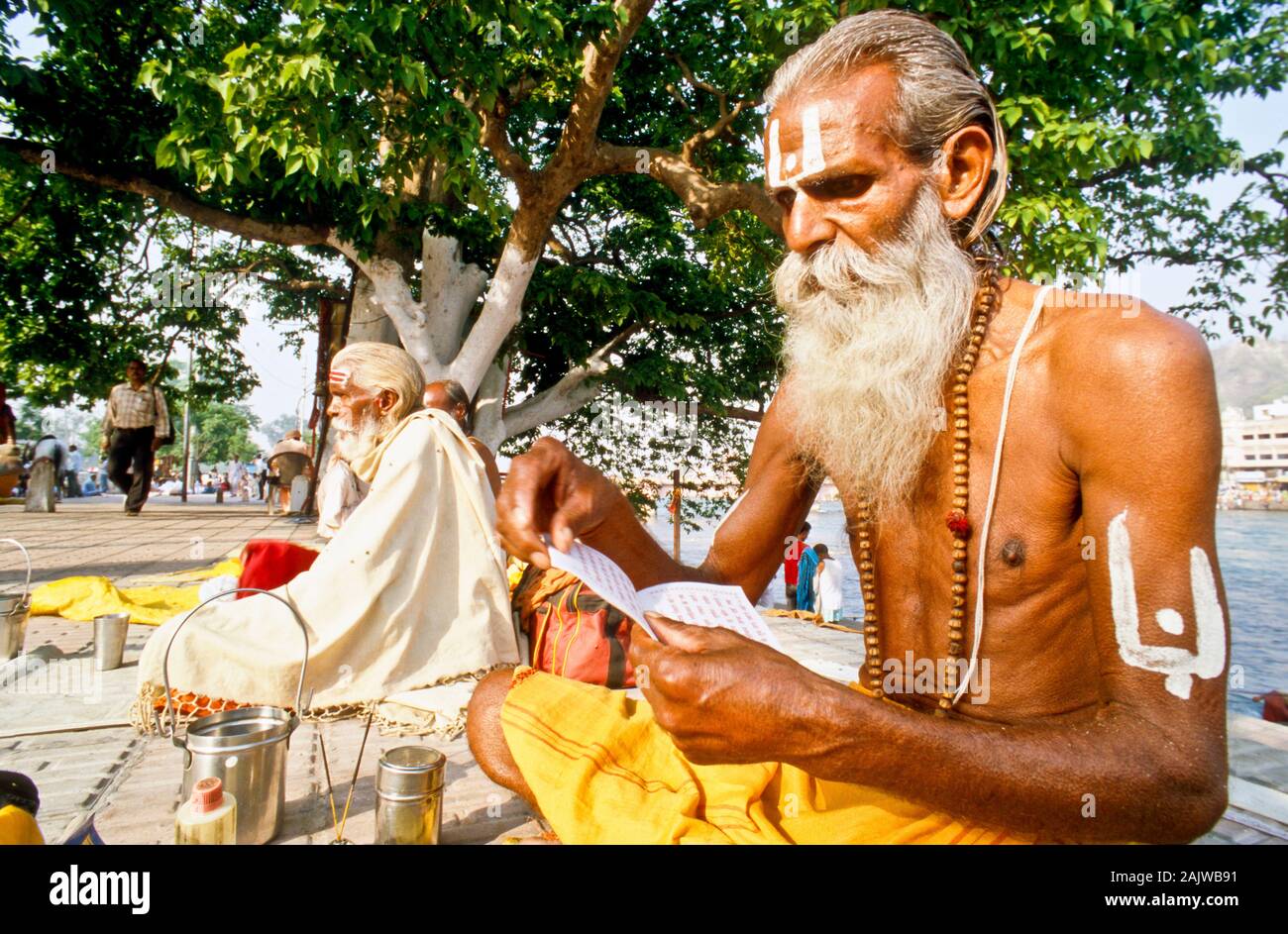 Un piccolo gruppo di Sadhus facendo loro mattina-pooja al ghats lungo il fiume Gange in Haridwar Foto Stock