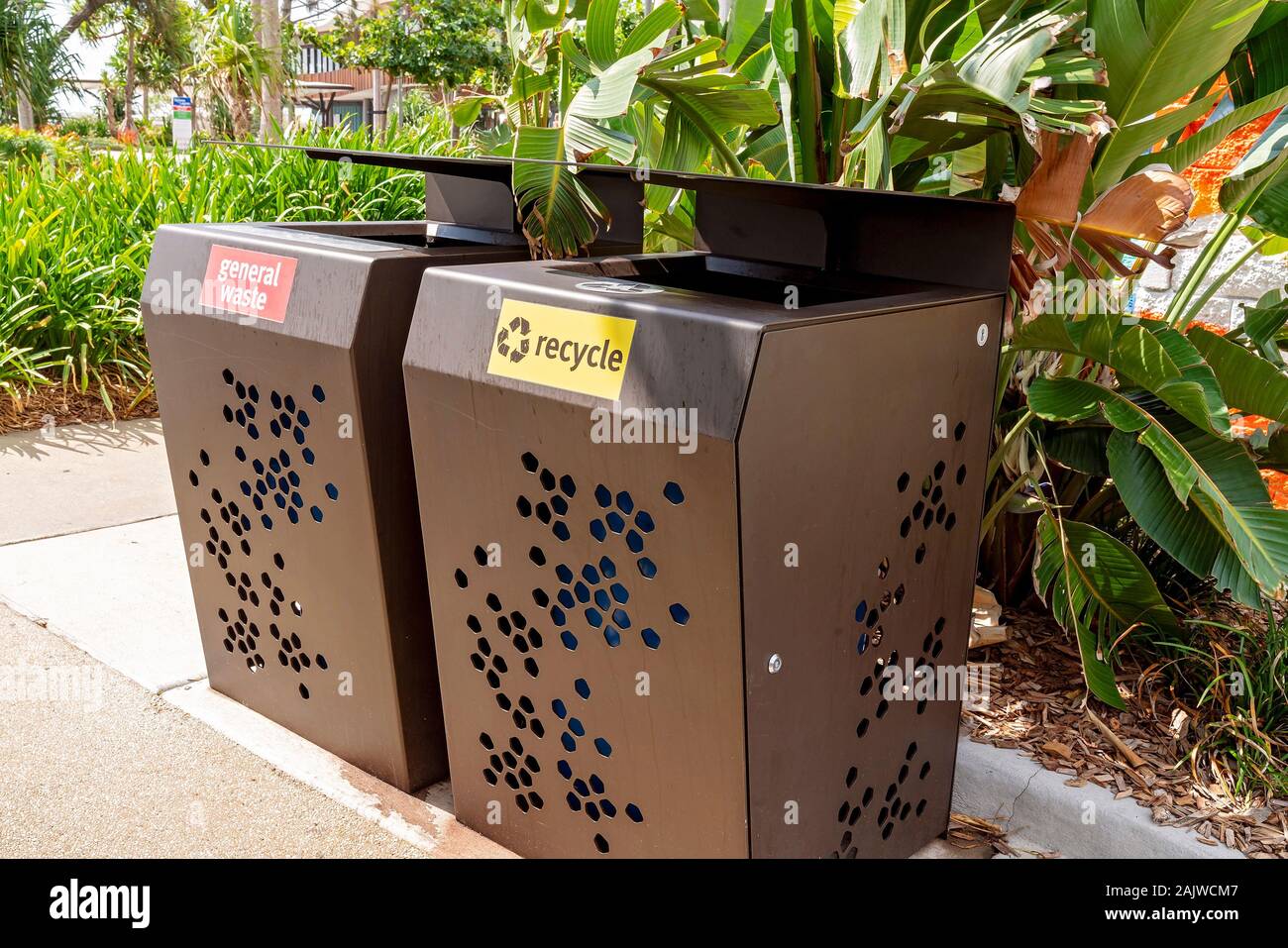I rifiuti generici e riciclare contenitori della spazzatura accanto a un  giardino in un pubblico esterno parco ricreativo Foto stock - Alamy