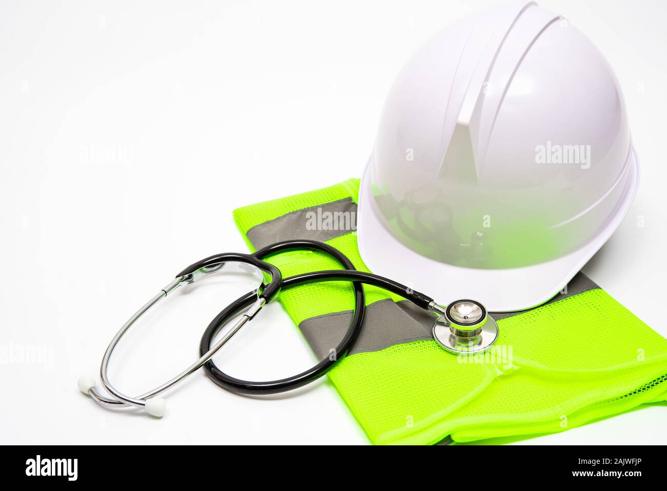 Su uno sfondo bianco, vi sono la sicurezza cappelli, abiti da lavoro, e stetoscopi. Foto Stock