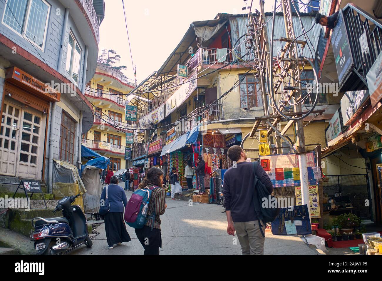 I viaggiatori guardano i variousGoods in esposizione nella piccola corsia di Bazaar di McLeodganj vicino Dharamshala in Himachal Pradesh, India Foto Stock