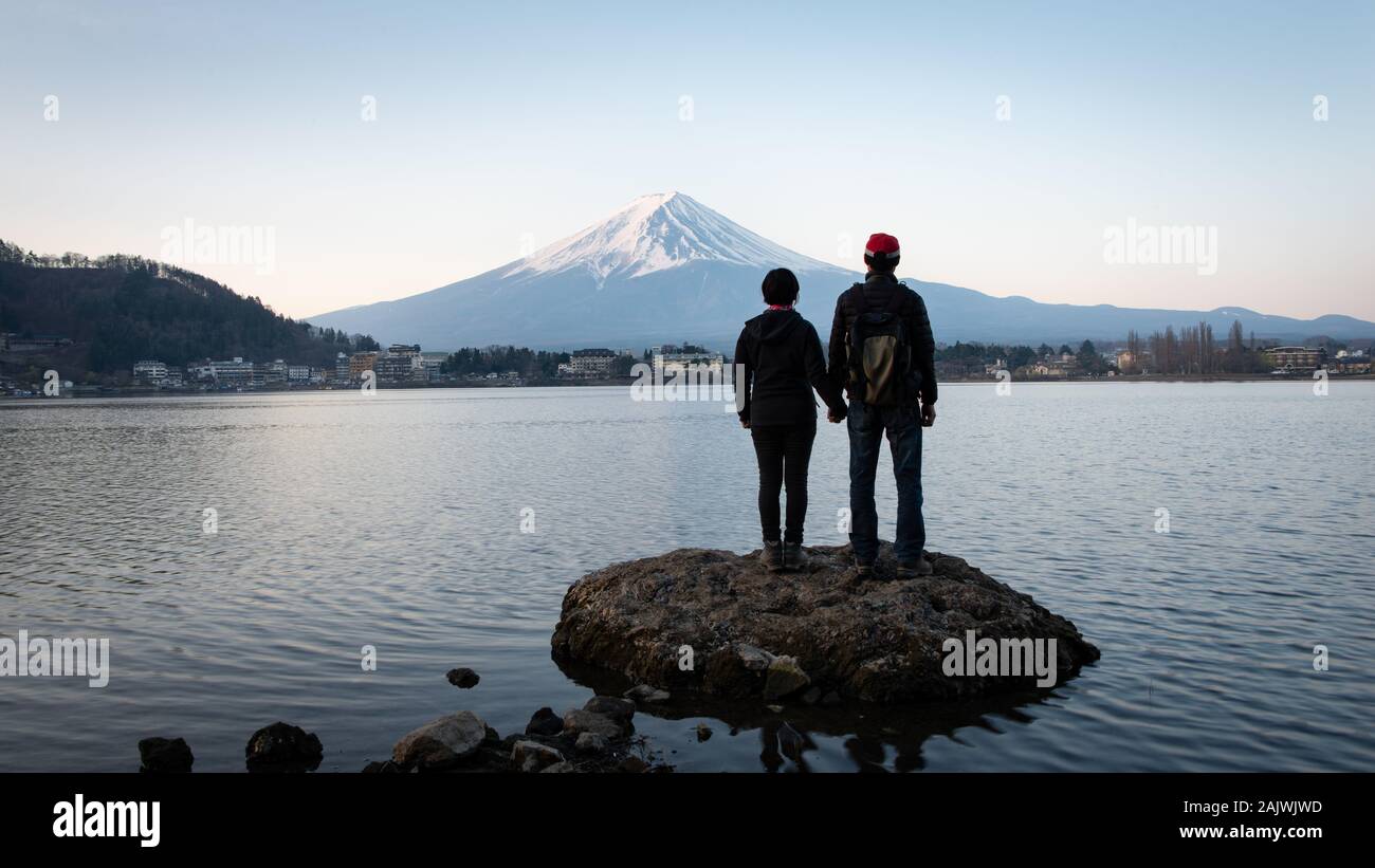 Un giovane godendo di Sunrise vista del Monte Fuji sulla riva settentrionale del Lago Kawaguchiko in Giappone Foto Stock