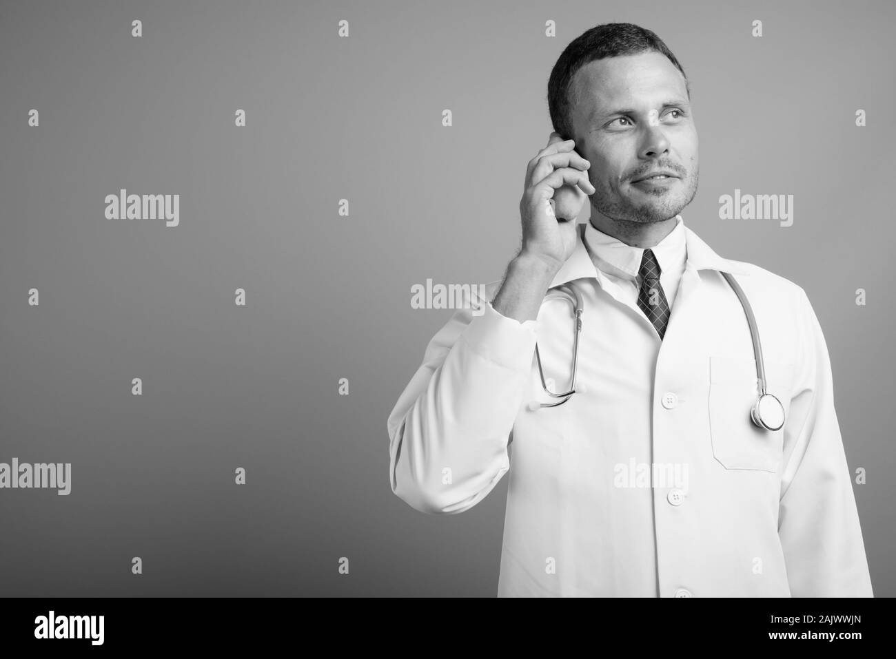 Ritratto di uomo bello medico contro uno sfondo grigio Foto Stock